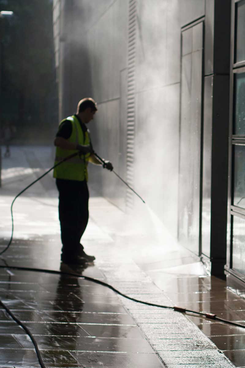 Power washing the sidewalk and walls